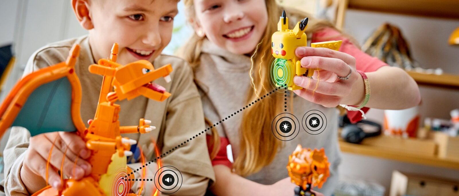 Enfants jouant avec les sets LEGO Pokémon SMART Play Dracaufeu et Pikachu