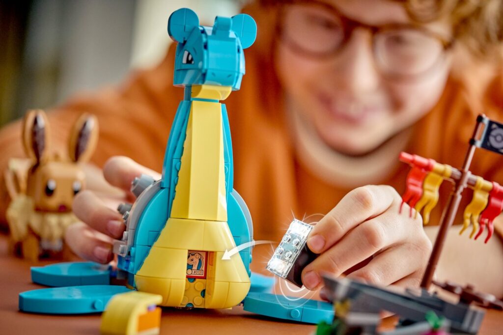Un enfant joue avec le set LEGO Pokémon Évoli et Lokhlass