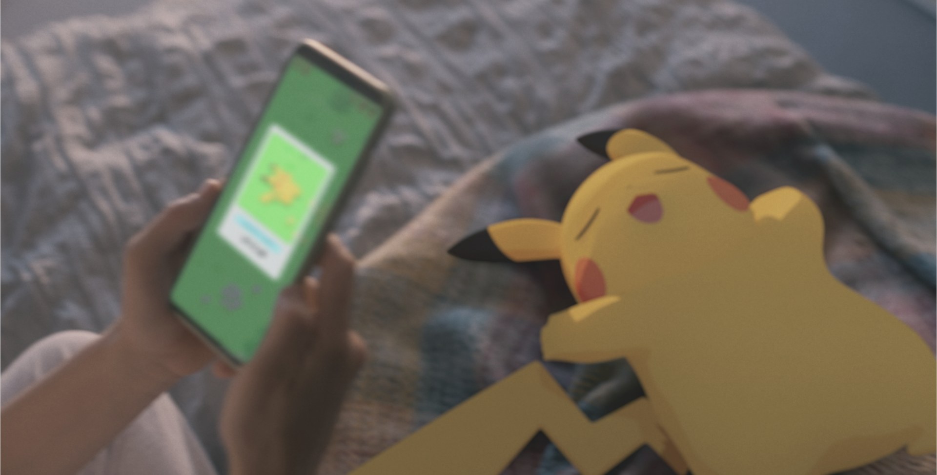 Pikachu endormi sur un lit à côté d'un smartphone ouvert sur Pokémon Sleep