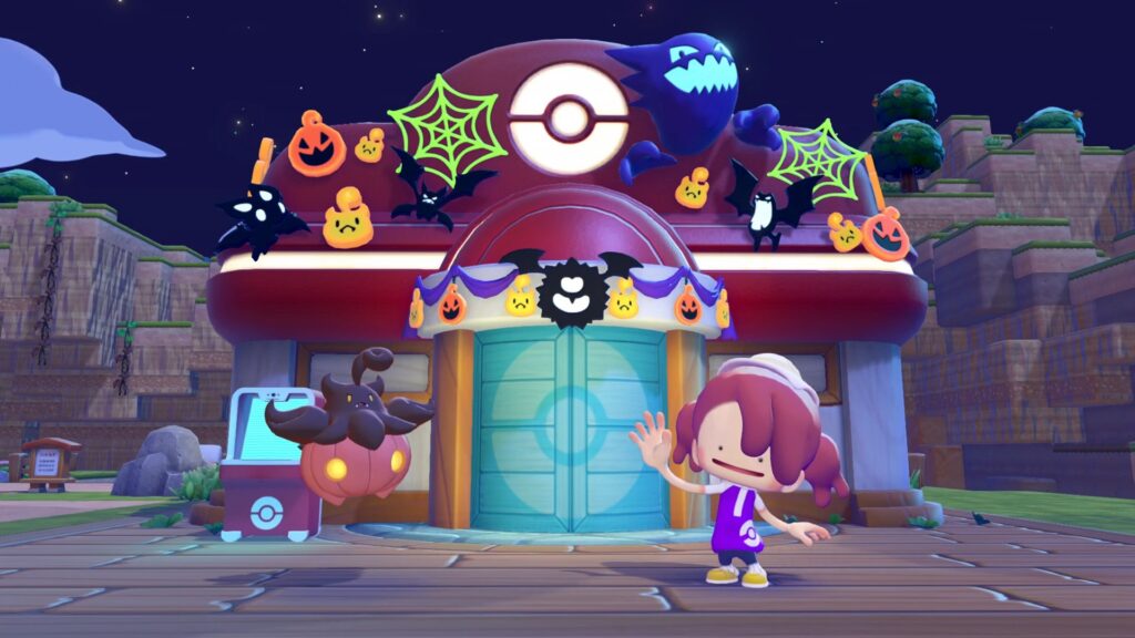 Pitrouille devant le Centre Pokémon décoré pour Halloween, avec toiles d'araignée, citrouilles et chauves-souris, et Métamorph qui salue