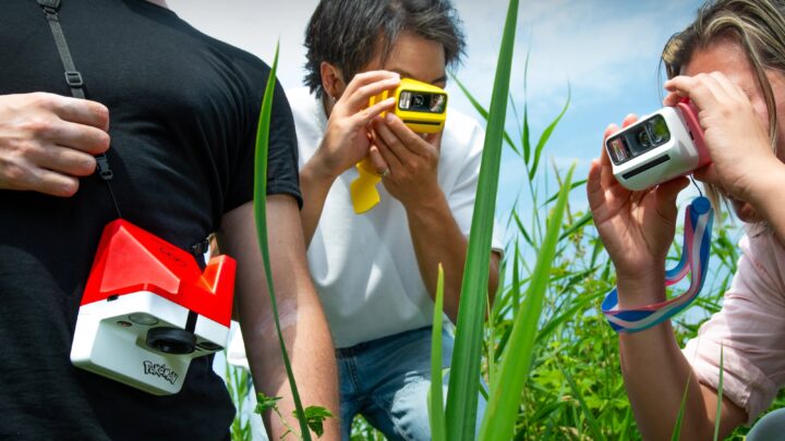 Trois amis photographient dans les herbes hautes avec les appareils Polaroid x Pokémon aux couleurs de Pikachu, de Nymphali et de la Poké Ball